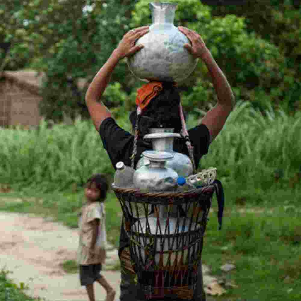 Mother and child walk long distance to acquire water which is often from contaminated water sources