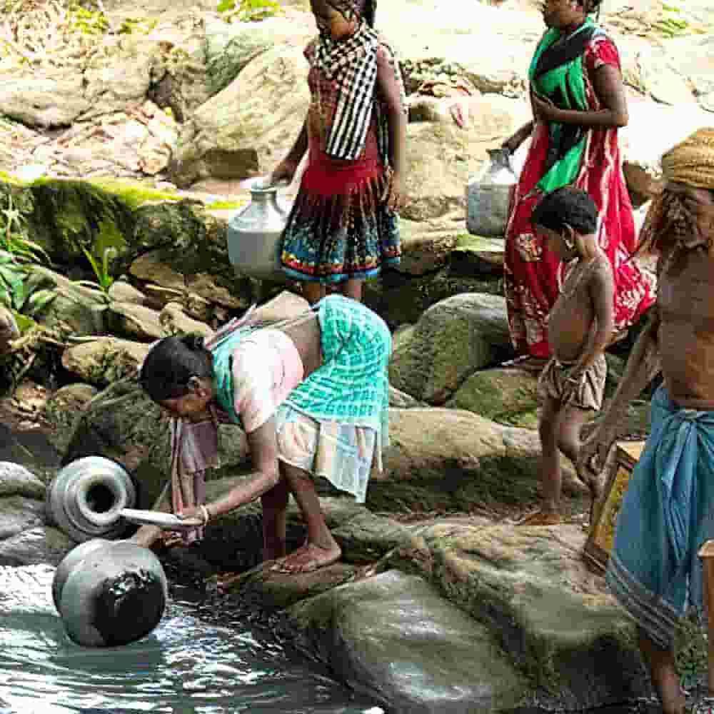 People from a village near Garjan’s gather water at an open source, which becomes contaminated during the rainy season. 