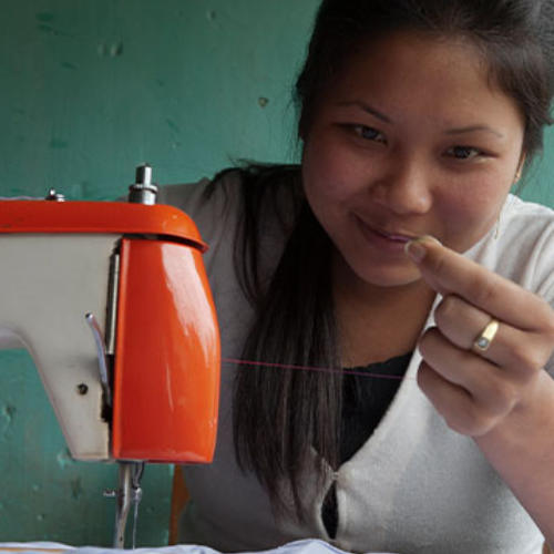 Woman learns how to use a sewing machine through GFA World tailoring class