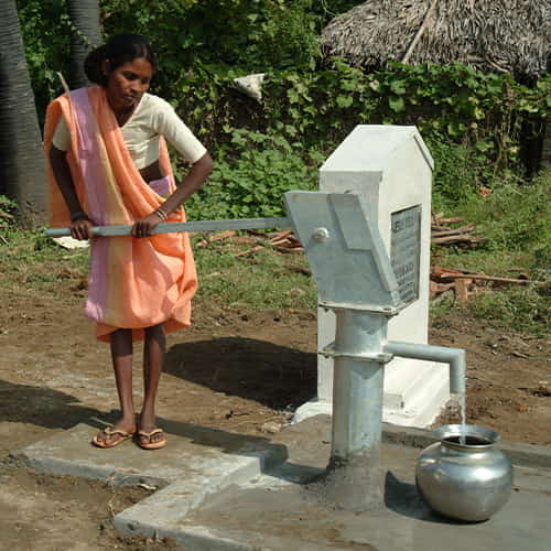 Woman drawing clean water through GFA World Jesus Wells