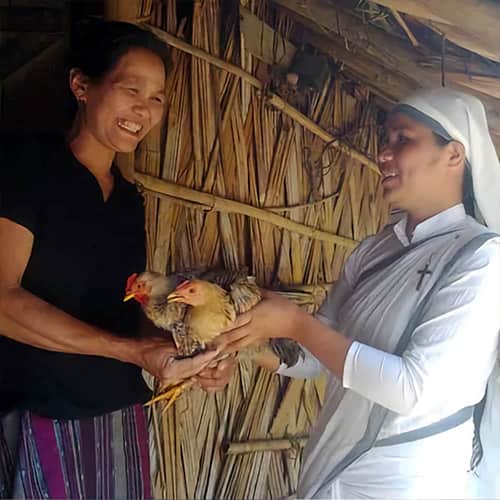 Woman receives income generating gift of a chicken from GFA World woman missionary