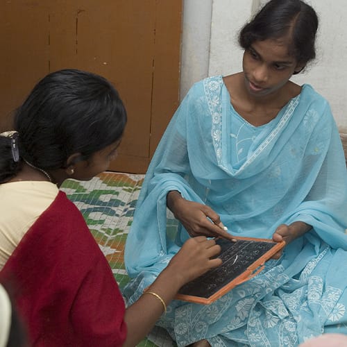 Woman missionary teaching women's literacy class