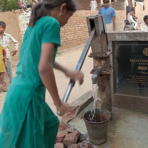 Girl drawing clean water through GFA World Jesus Wells