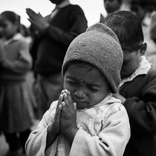 Young child praying before enjoying a nutritious meal in GFA World (Gospel for Asia) child sponsorship program