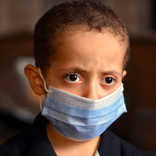 Young boy wearing a facemask amid the COVID-19 pandemic and lockdowns