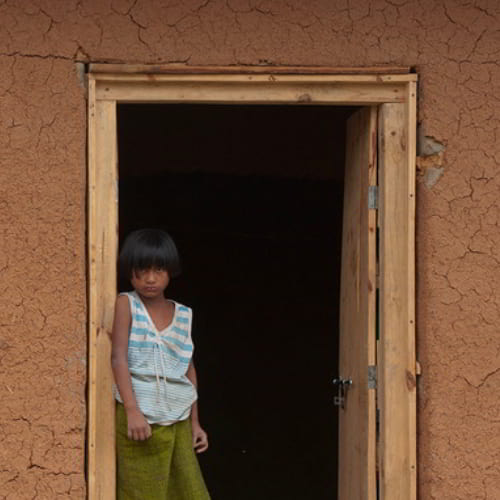 Girl in poverty standing in a doorway