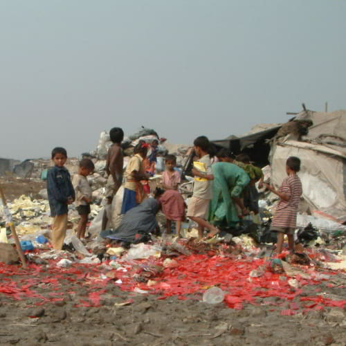 Children wading through waste in South Asia slums