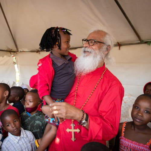 GFA World founder KP Yohannan and national missionary workers sharing tangible help to the children of Rwanda, Africa through child sponsorship