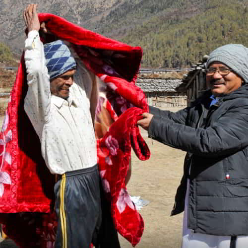 Man receives a warm blanket through GFA World gift distribution
