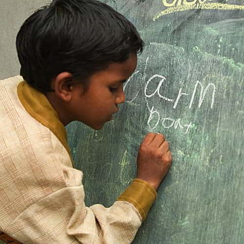 Young boy learns how to read and write through GFA World child sponsorship program