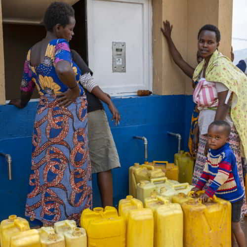 Village women collecting clean water through GFA World Jesus Wells in Rwanda, Africa