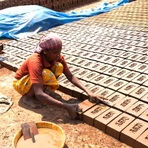 Woman in poverty working in a brick kiln