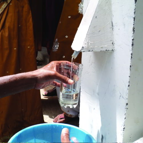 Man drawing water from GFA World BioSand water filter