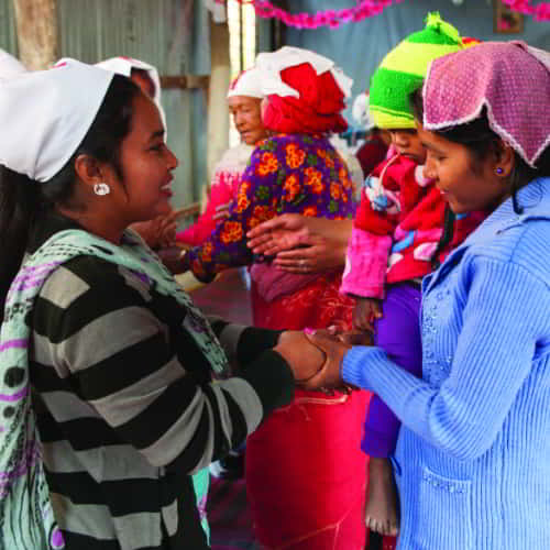 A woman missionary demonstrating personal concern to an impoverished family in South Asia as an expression of Christ's love