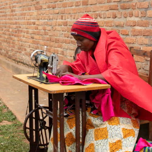 Women learn how to use sewing machines through GFA World tailoring class