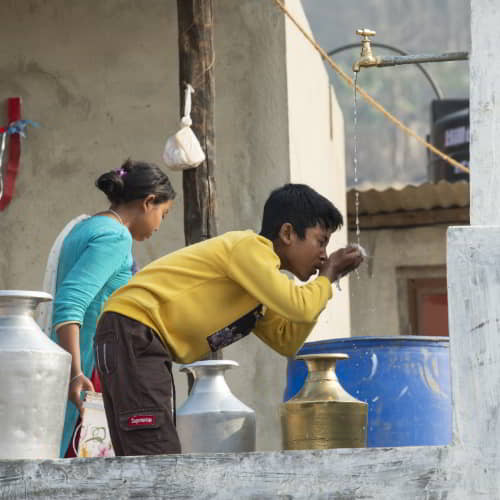 Young boy drinking clean water through GFA World Jesus Wells