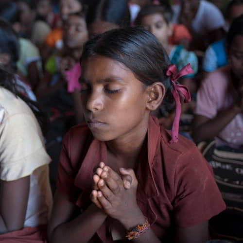 Young girl praying in GFA World child sponsorship program