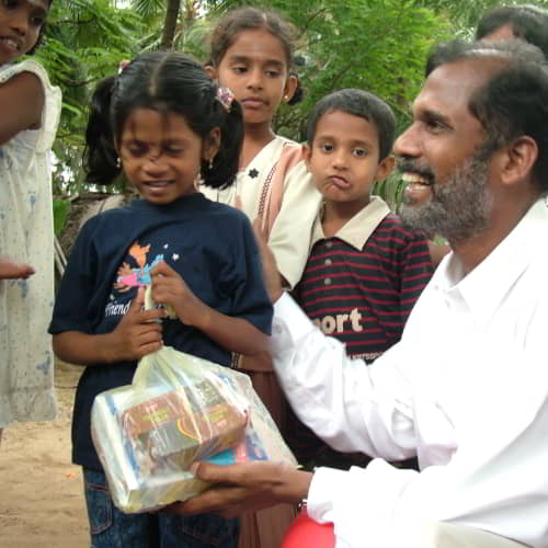 GFA World national missionary distributing school supplies to children