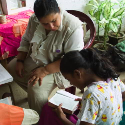 A woman missionary instructing a girl in GFA World child sponsorship program