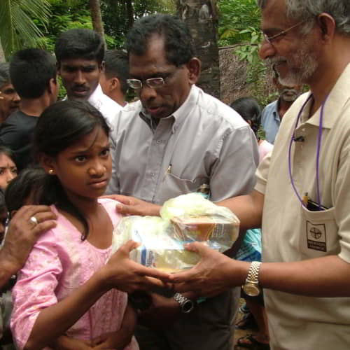 GFA World founder KP Yohannan assists in distributing gifts to children