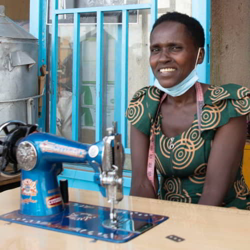 Woman in poverty received an income generating gift of a sewing machine through GFA World Christmas gift catalog