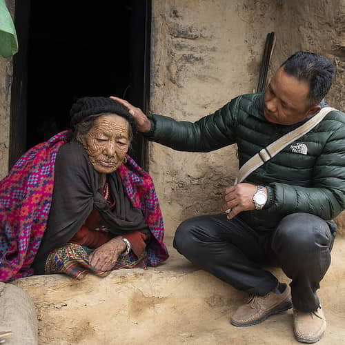 GFA World national missionary praying for an elderly woman