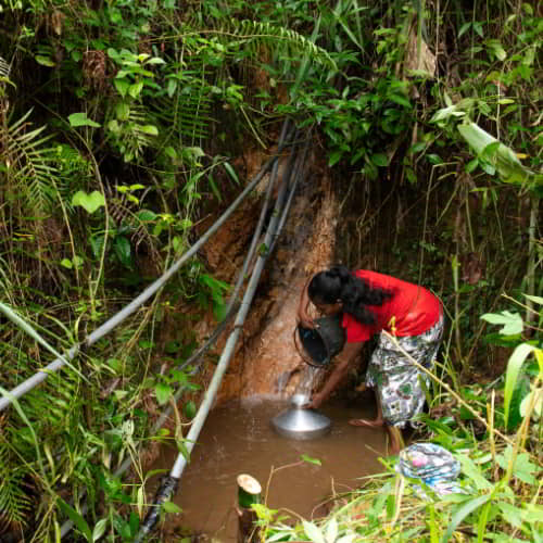 Woman collecting unclean water