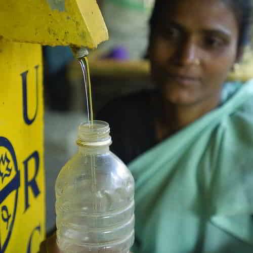 Woman drawing clean water through GFA World BioSand water filter
