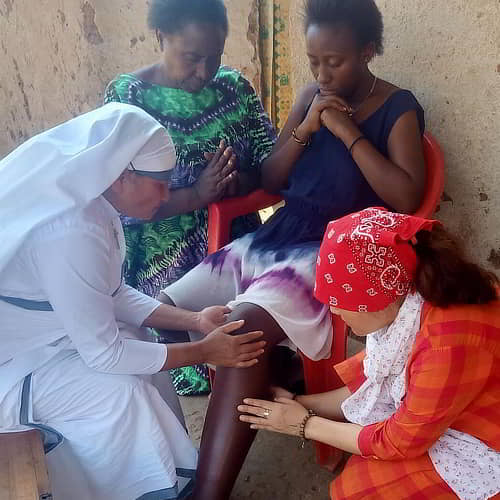 GFA World women national missionaries praying for a woman's healing