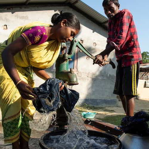 Family washing clothes with clean water from GFA World Jesus Wells