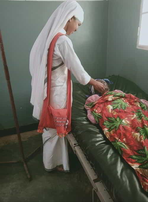 Sisters of the Cross sharing the love of Jesus to a sick woman