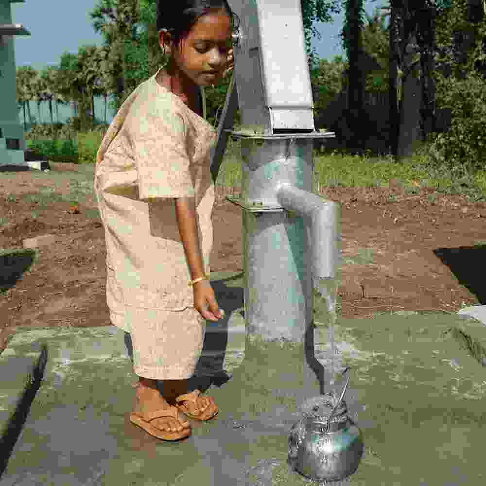 Girl drawing clean water from GFA World Jesus Wells