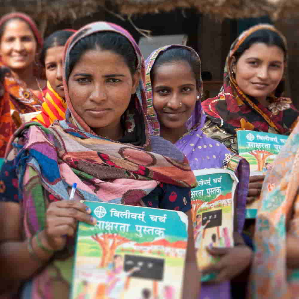Women and their literacy workbooks given by GFA World adult literacy class