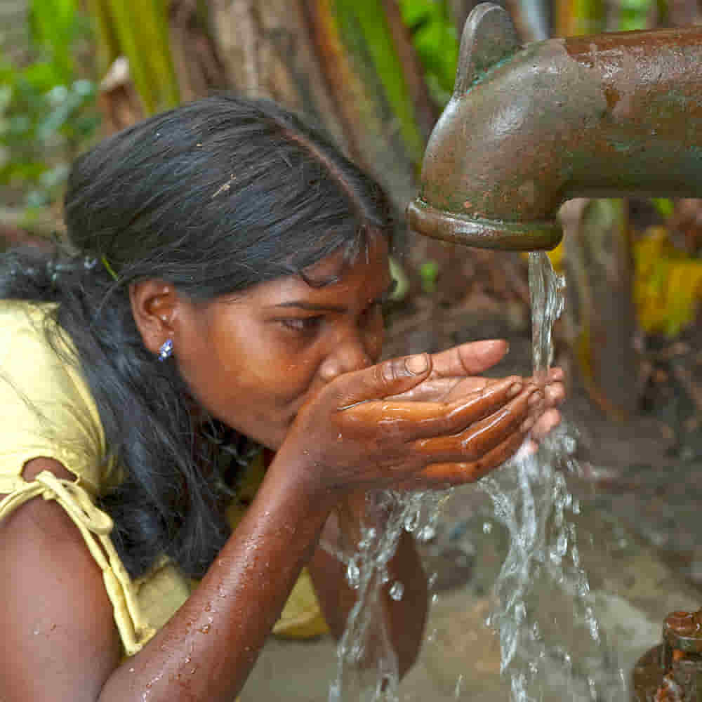 Young woman drinking clean water from Jesus Wells