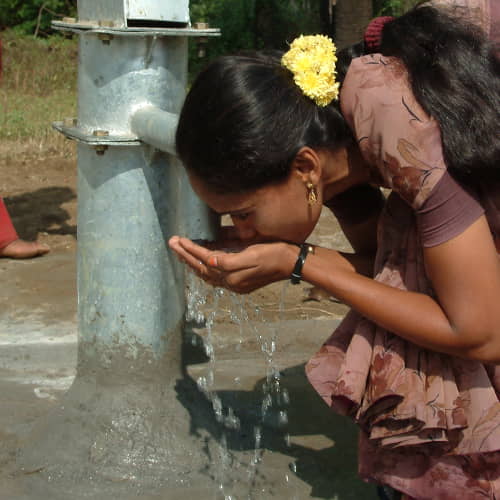 Woman drinking clean water through GFA World Jesus Wells