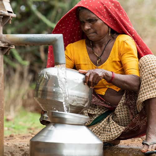 Woman washes her pots with clean water through GFA World Jesus Wells