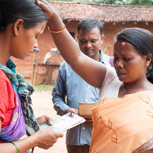 GFA World women missionaries praying for a woman
