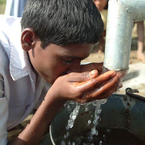 Young boy drinking clean water from GFA World Jesus Well