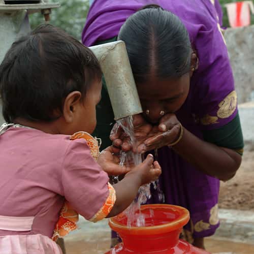 Woman and little girl drinking clean water through GFA World Jesus Wells