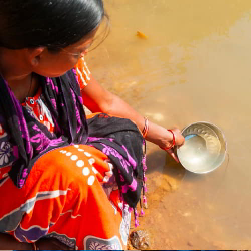 Woman collecting unclean river water