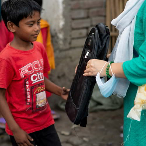 Young boy received a school bag through GFA World child sponsorship program supplies distribution