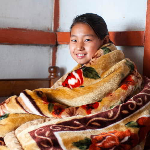 Young girl received a cold weather relief warm blanket through GFA World gift distribution