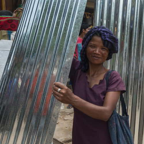 Woman in poverty received a tin roof through GFA World gift distribution